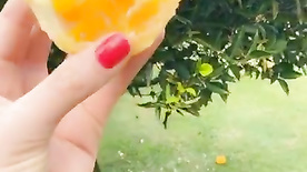 Gostosa sem calcinha chupando laranja