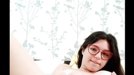 Branquinha de óculos batendo siririca nua em sua cama