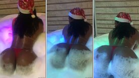 Vanessa Rodrigues com touquinha de mamãe noel rebolando rabão na banheira de espumas